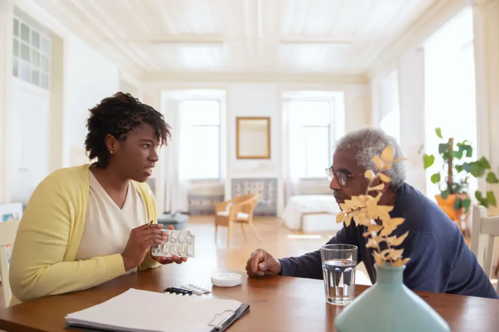 Caregiver giving a senior a medication reminder