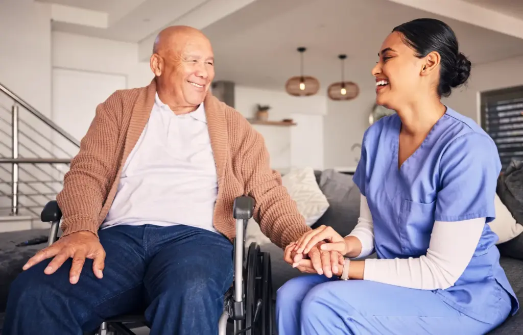 Caregiver laughing with a senior man at home